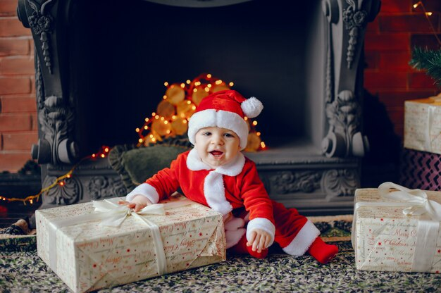 A baby laughing near Christmas presents. 