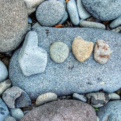 Photo of natural stones shaped liked letters. They spell LOVE.