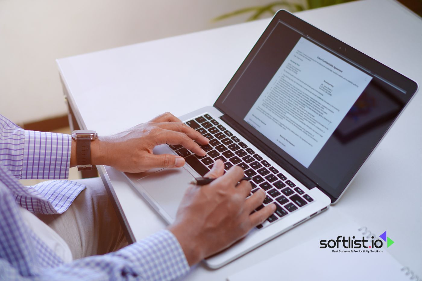 Person working on a laptop with a document on screen