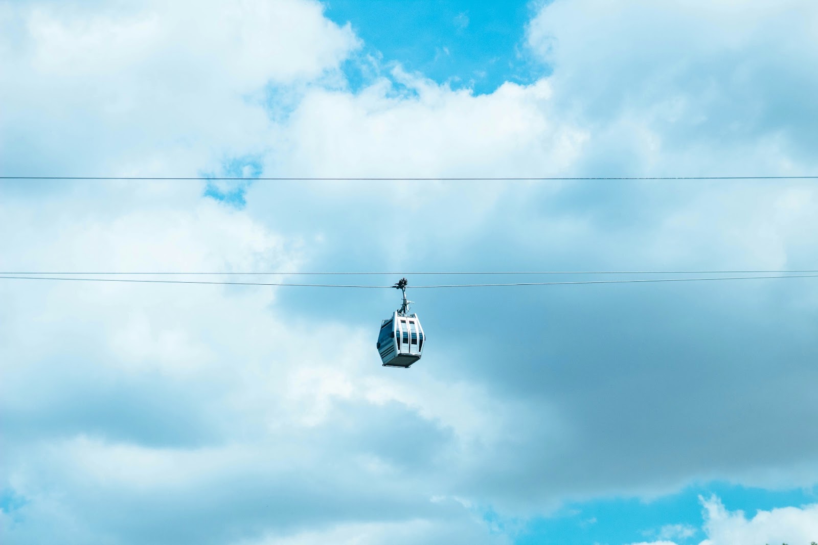 Travelers ascending the cliffside of Santorini via cable car.