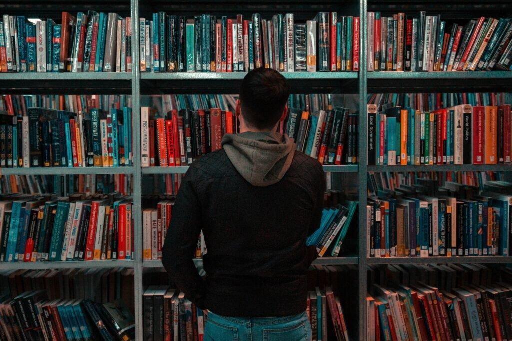 person looking at books in library - Study Strategies