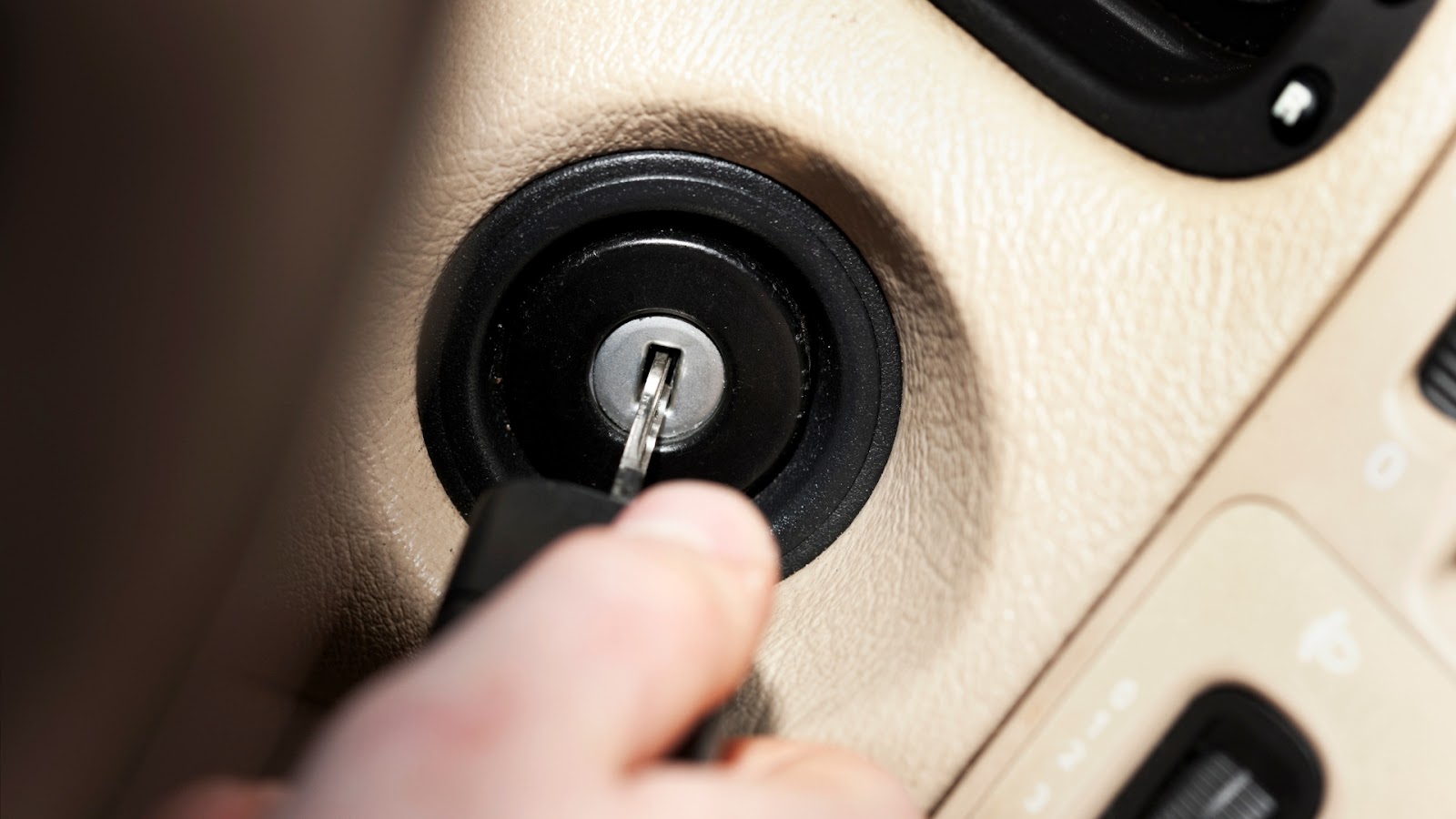A user inserting a key into the ignition switch
