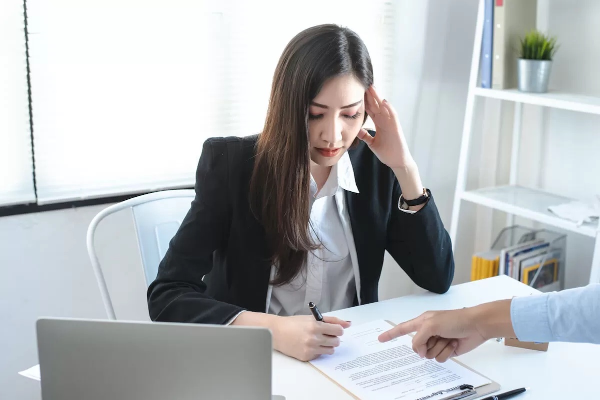 Stressed woman signing a document