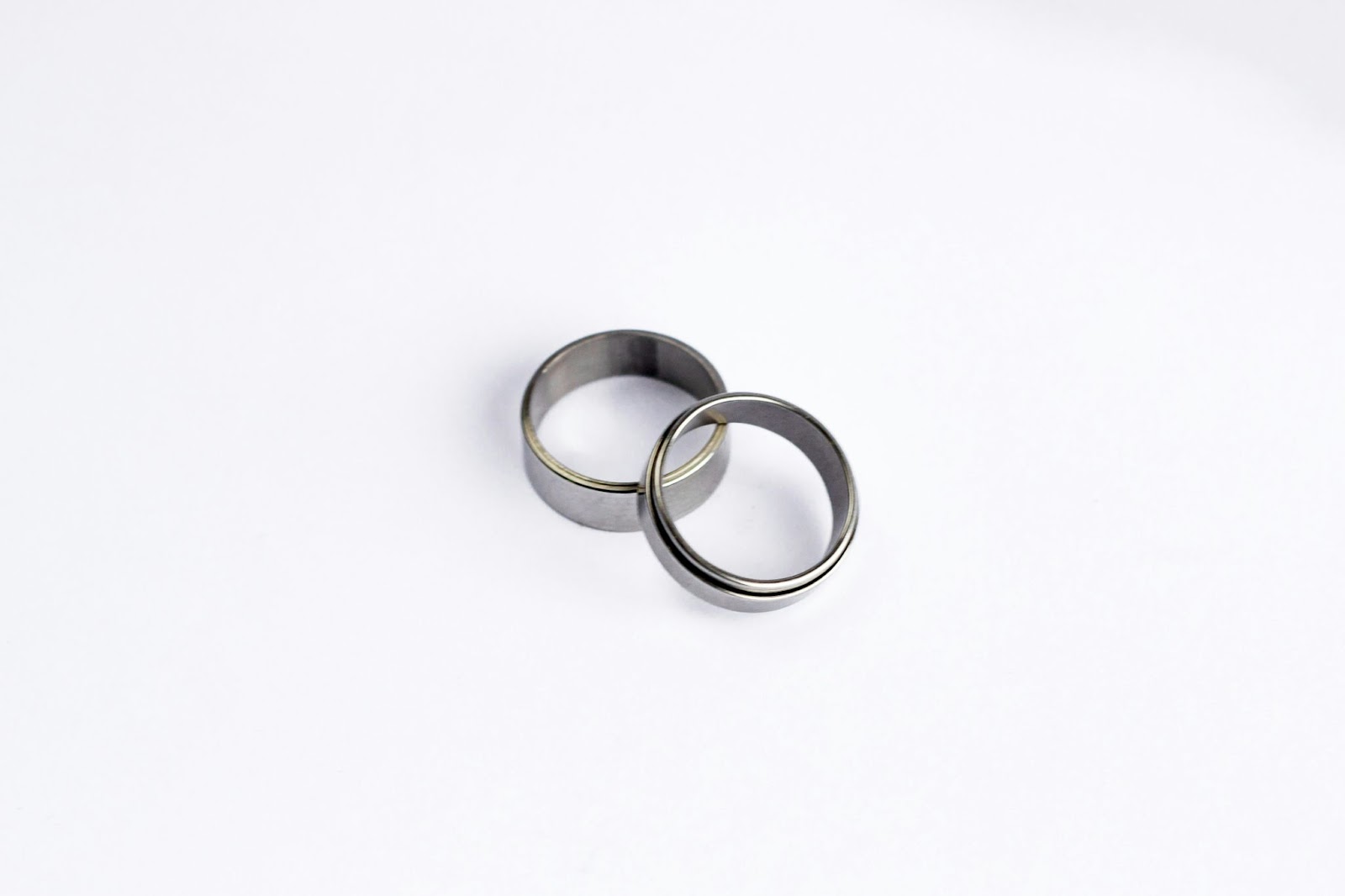 Matching silver weddings bands on white background.