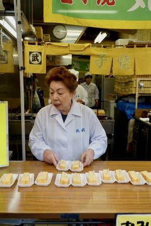 A Japanese woman serving omelettes.