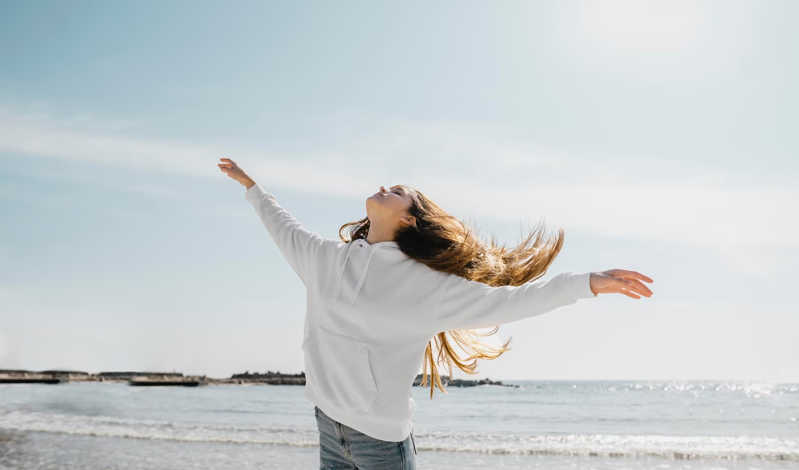 A woman enjoying the ocean breeze and living life.