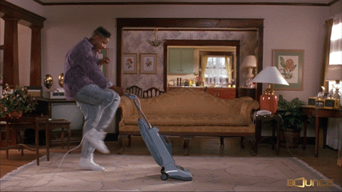 Man dancing while cleaning the house