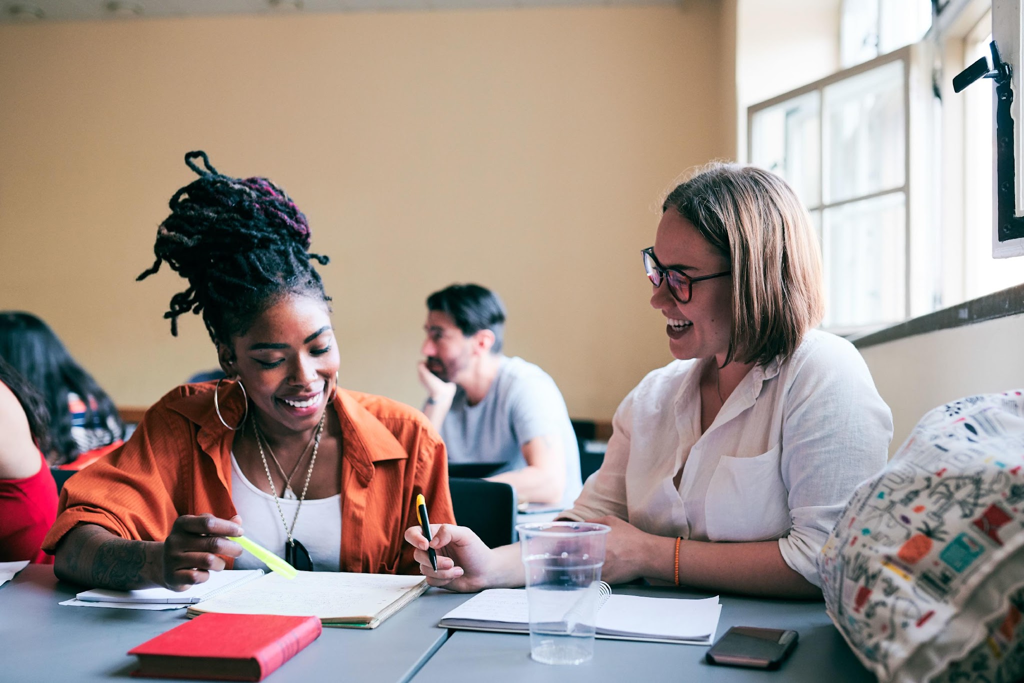 Two people collaborating over books