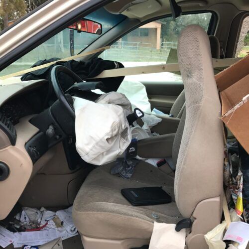 A spring hill car accident scene showing the inside of one of the cars involved in the accident. Airbags are deployed and the seat is pushed forward.
