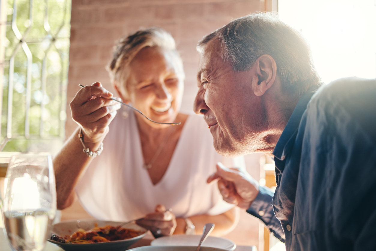 Senior woman feeding husband with spoon