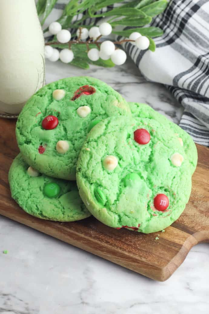 green sugar cookies with chocolate bits and mixins on wood board
