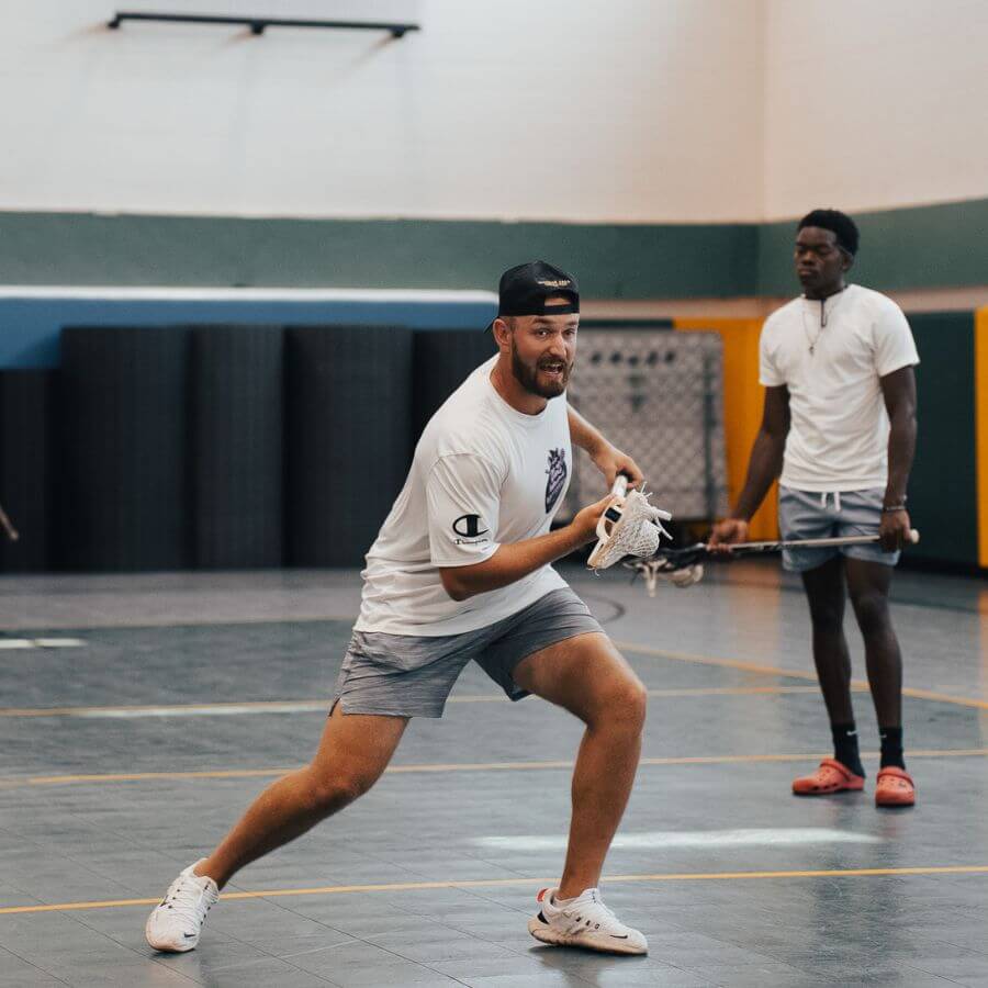 Professional lacrosse player providing instruction during an overnight sports camp session