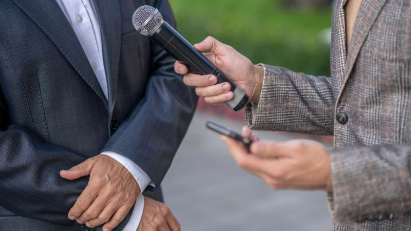 Corresponsal con un micrófono en la mano