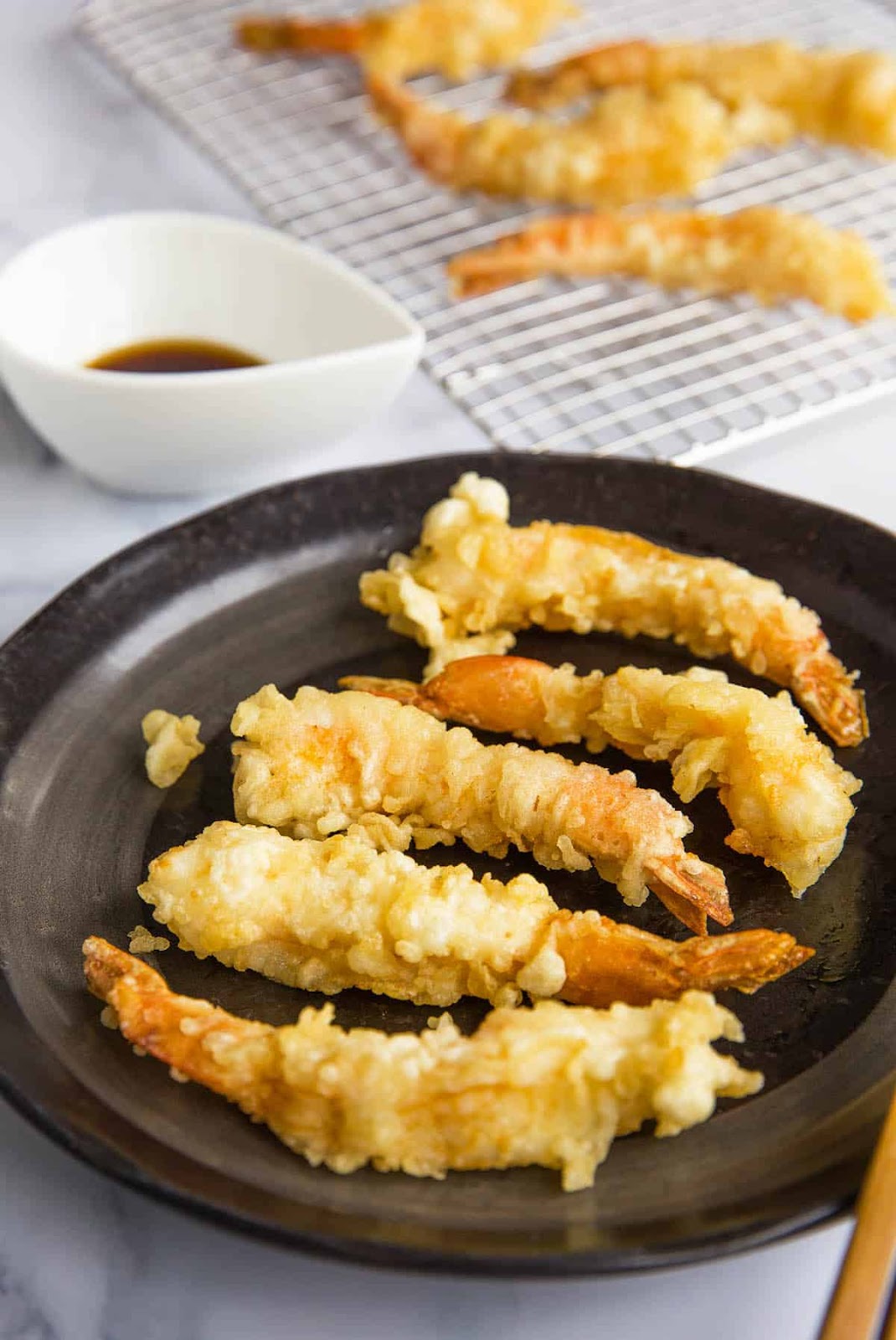 Ebi tempura served with dipping sauce.