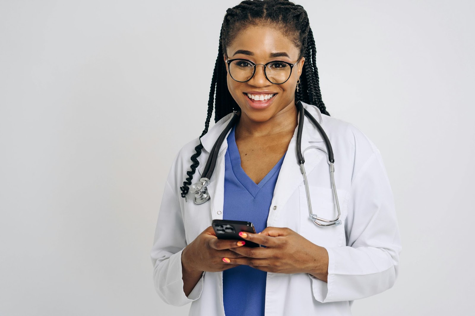 Female doctor smiling while holding a phone