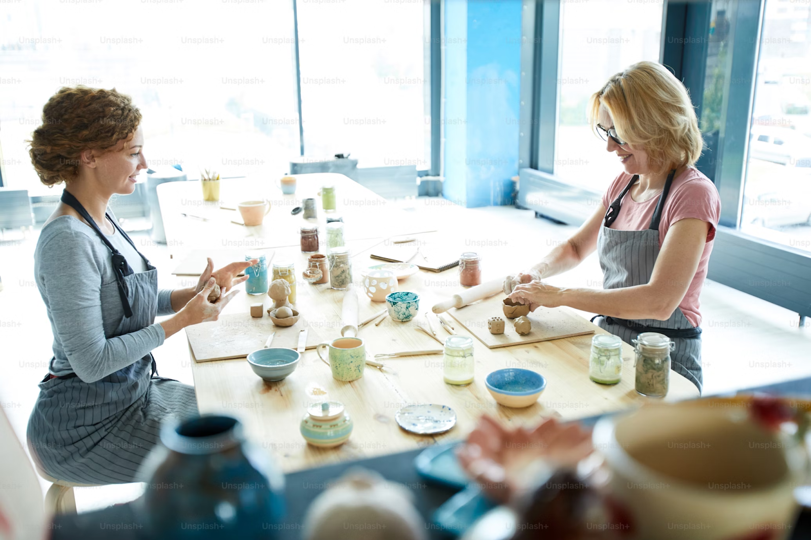 Two female creative artists working on clay