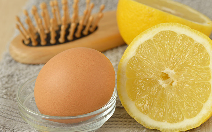 egg and lemon with hair brush on grey towel