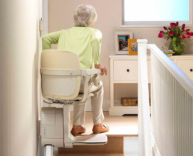 A lady sitting on a Stannah stairlift 