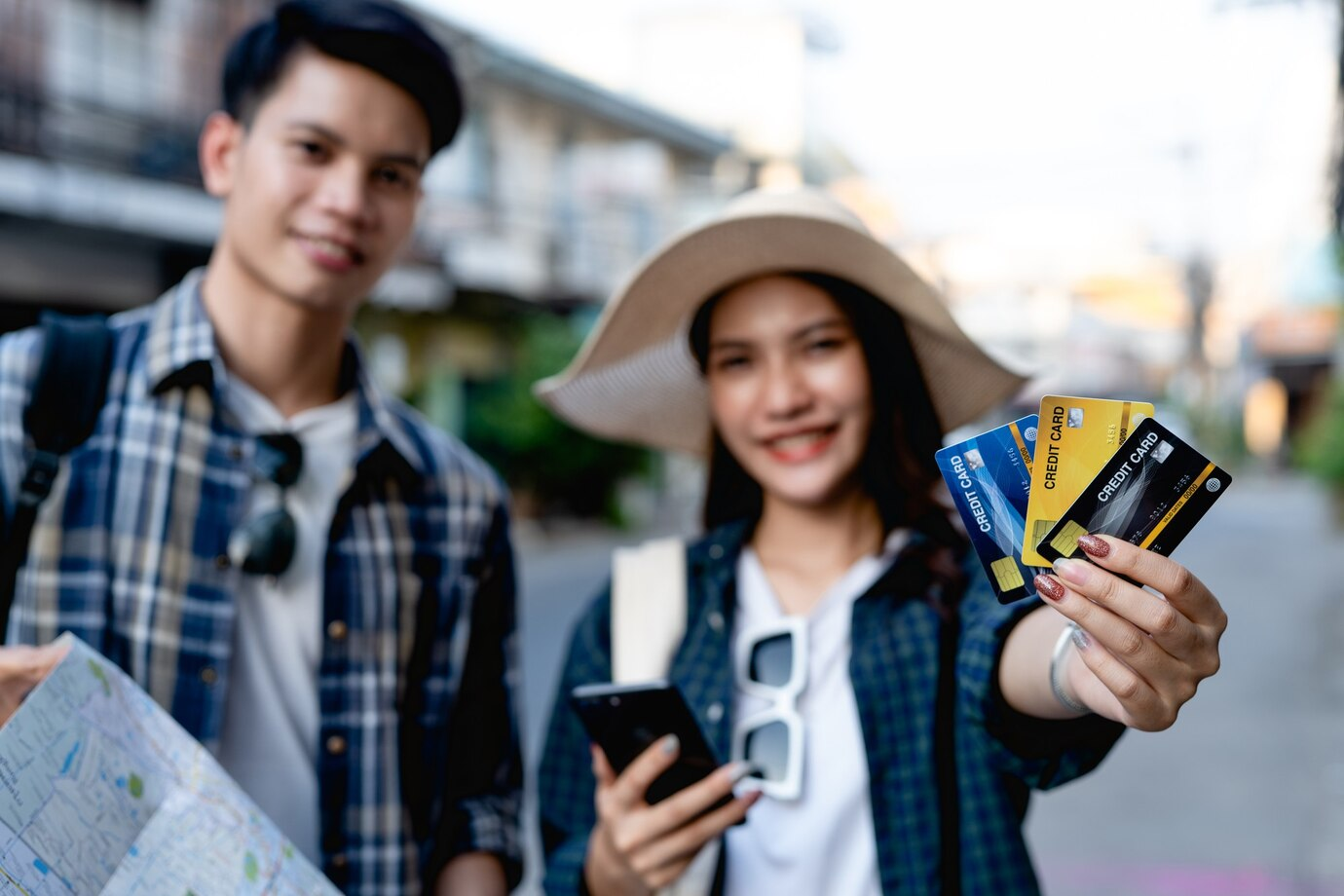 Maximizing travel rewards - Couple backpackers holding credit cards.