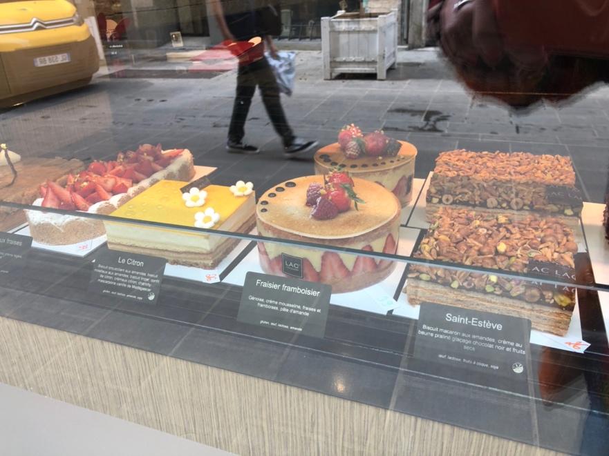 A display of cakes on a glass case

Description automatically generated