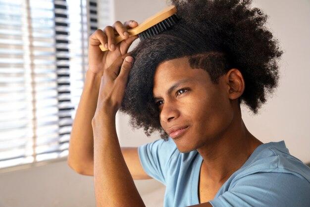 Free photo young black person taking care of afro hair