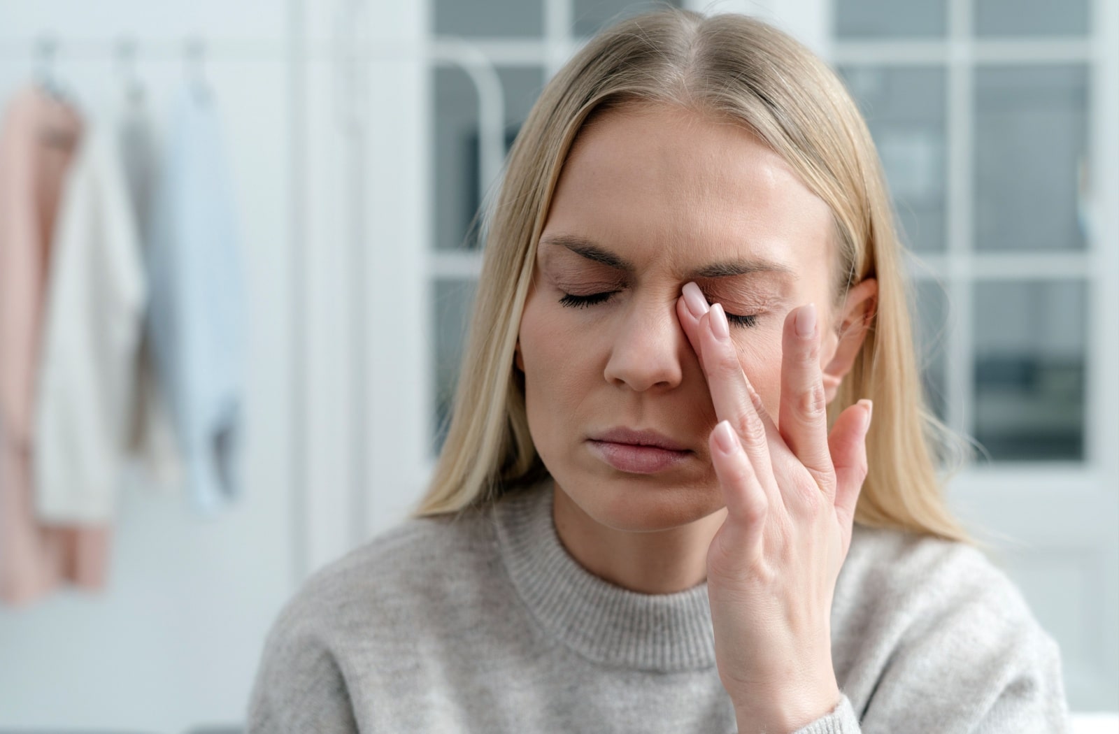 A woman rubbing her eyes due to dry eye symptoms