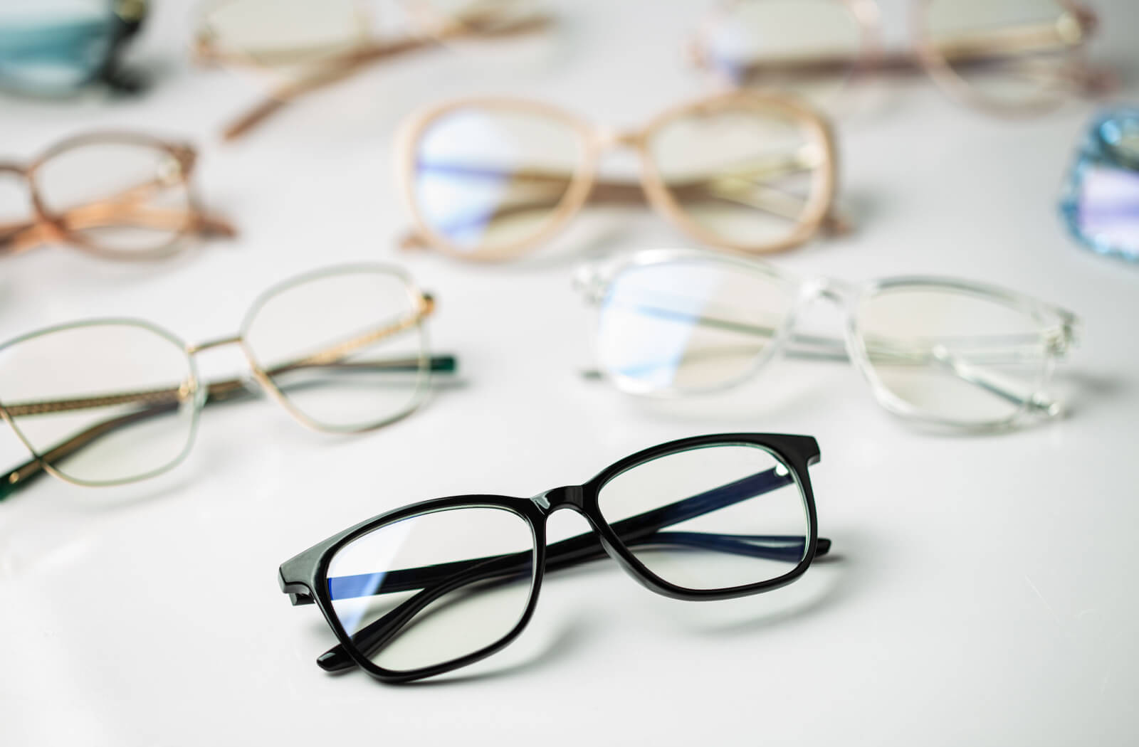 A collection of eyeglasses on a white backdrop.