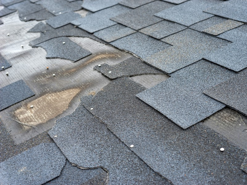 Closeup of a damaged roof missing shingles