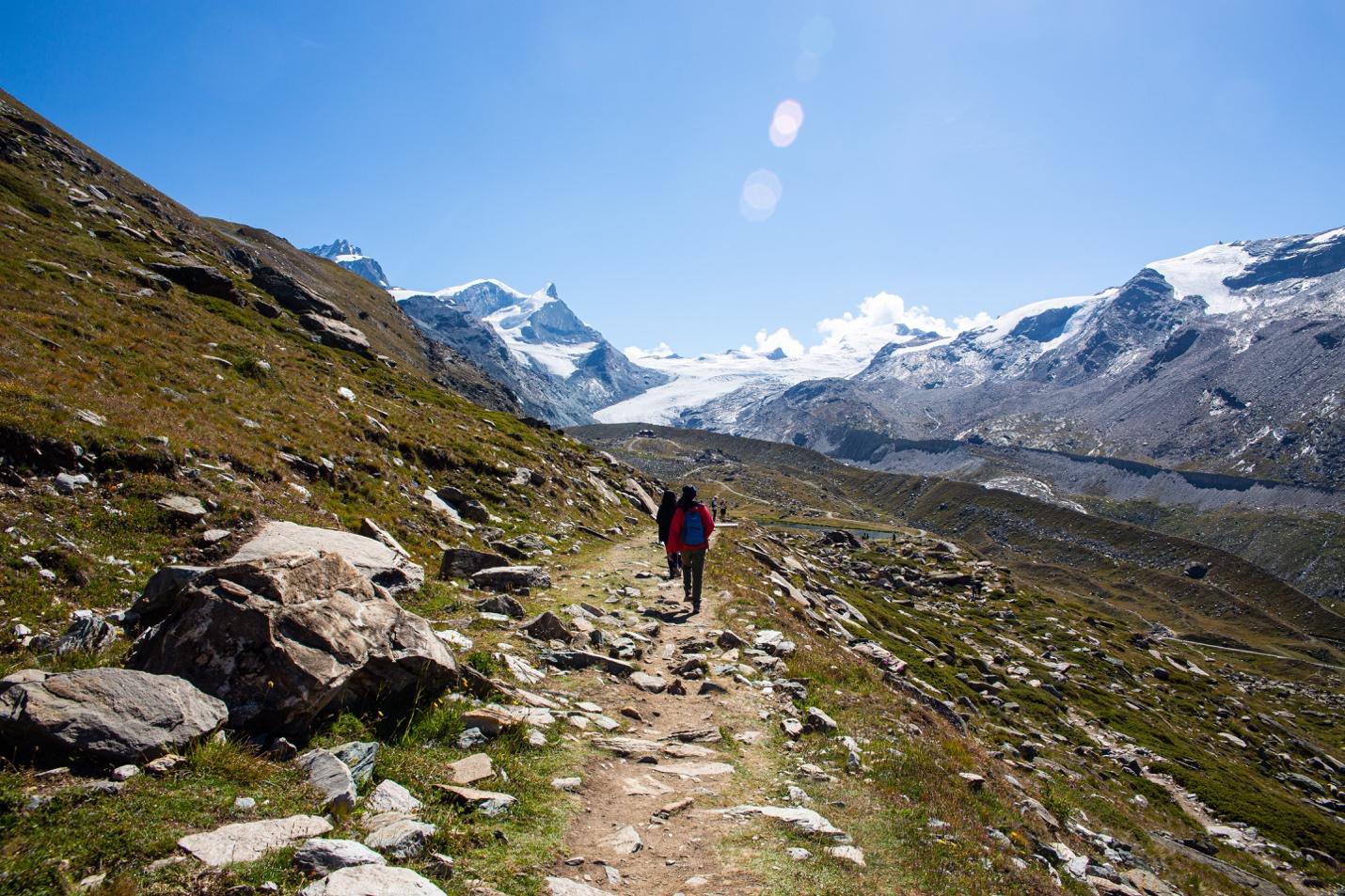 A person walking on a mountain path

Description automatically generated