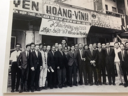 A group of men in suits standing in front of a building

Description automatically generated