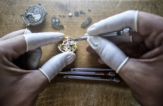 Watchmaker is repairing the mechanical watches in his workshop - a person is working on a watch