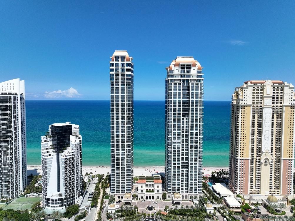 A group of tall buildings next to a beach

Description automatically generated