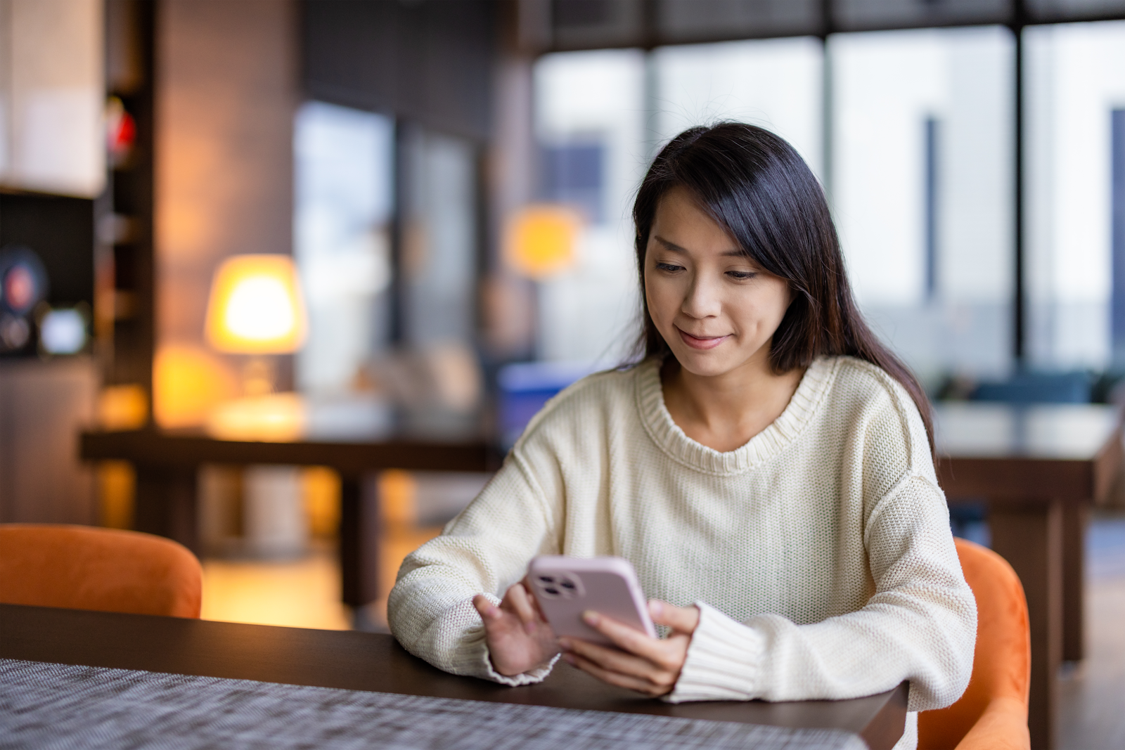 lady sitting in public setting on her phone