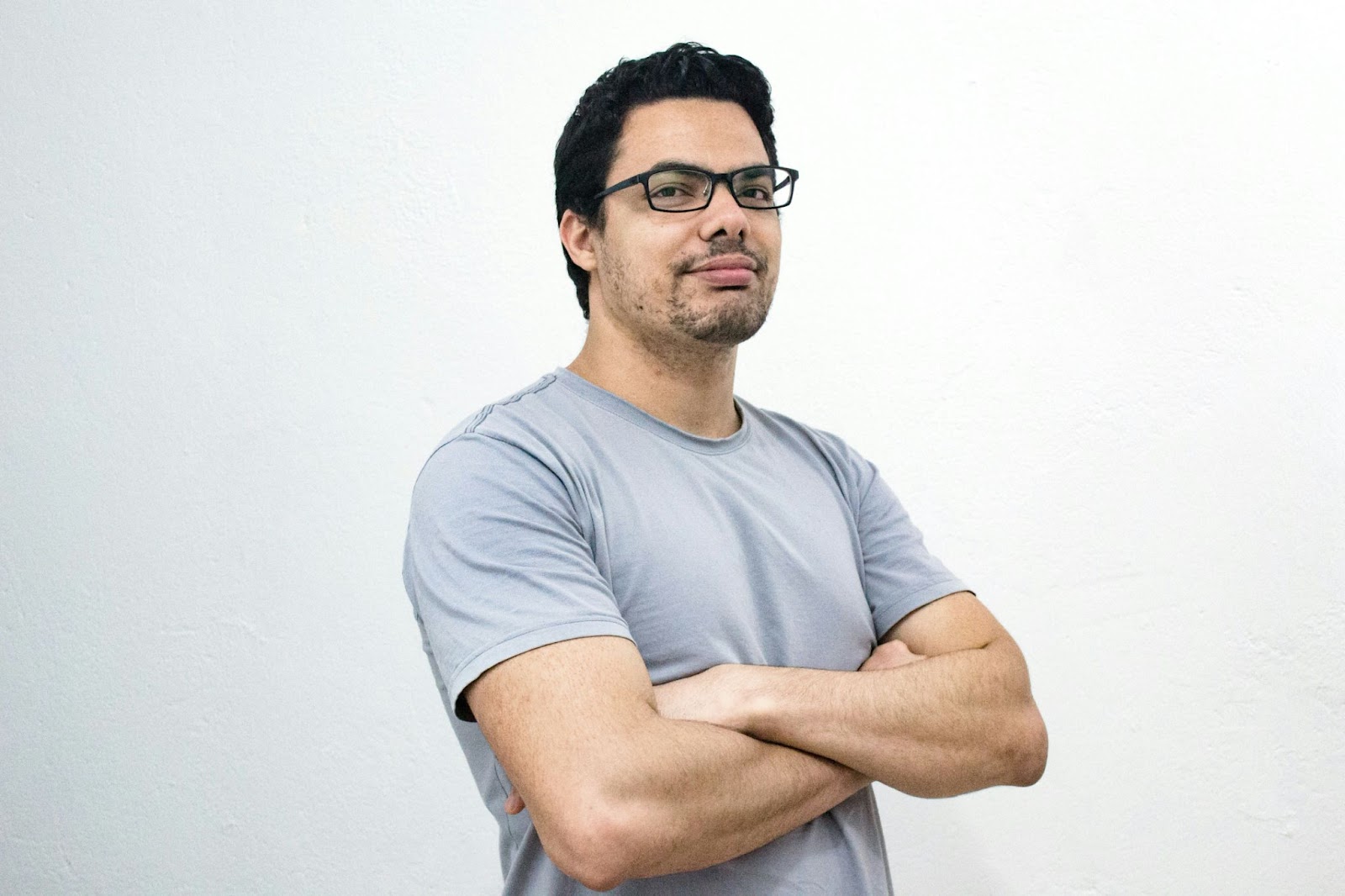 A man wearing spectacles giving the arms crossed pose to exude confidence for his modelling headshot