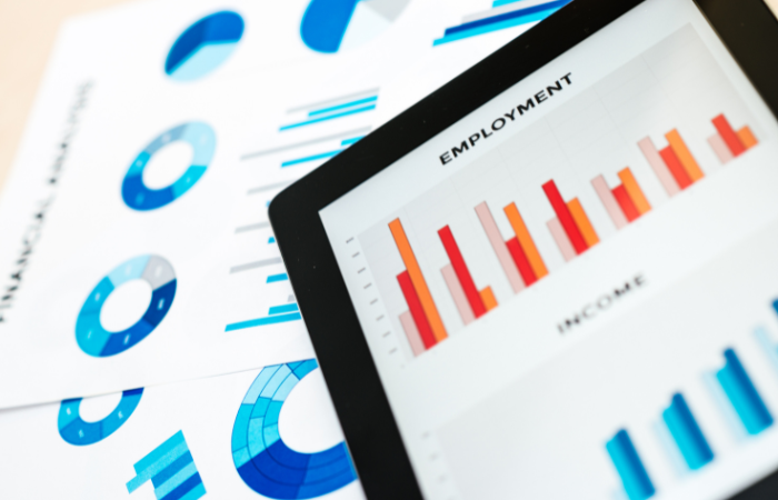 An array of economic graphs on a tablet, possibly analyzing labor market trends impacting the real estate market.