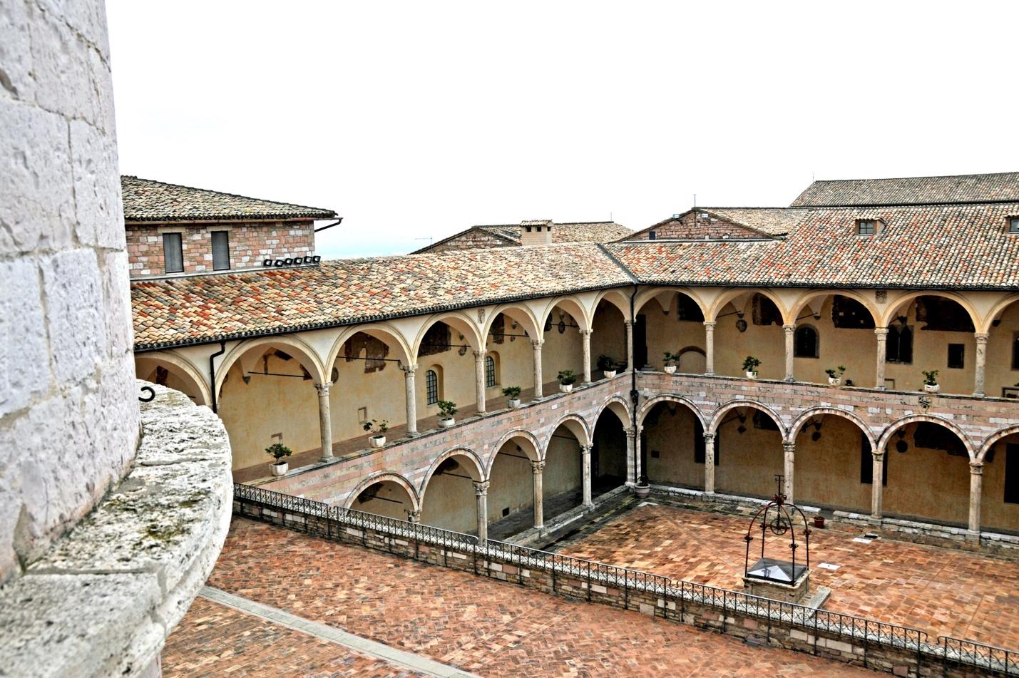 A photo of the courtyard of a large building, with porticos. Source: https://upload.wikimedia.org/wikipedia/commons/e/e8/%22_Basilica_di_San_Francesco_%28Assisi%29_Sacro_Convento_%22.jpg.