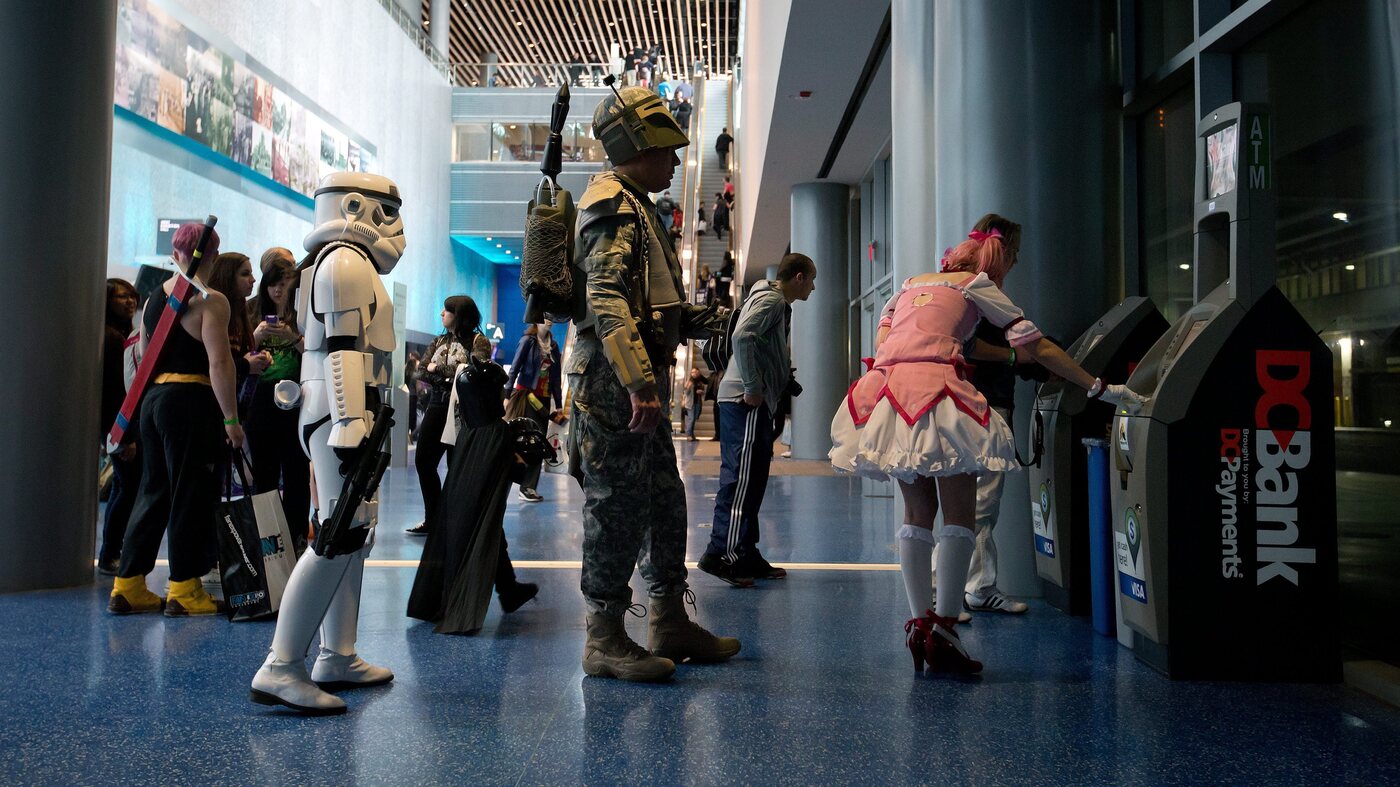 Anna Swope, dressed as a stormtrooper from Star Wars, and her husband Stephen Goss, dressed as the films' Boba Fett, wait to use an ATM while attending the Fan Expo convention in Vancouver, B.C.