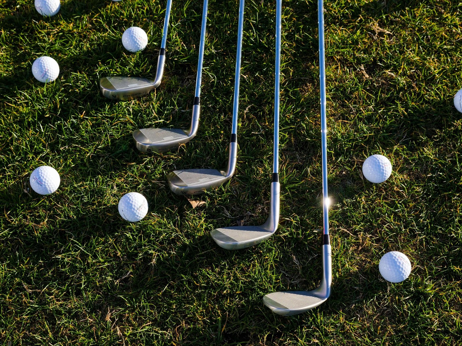 golf clubs and golf balls on grass