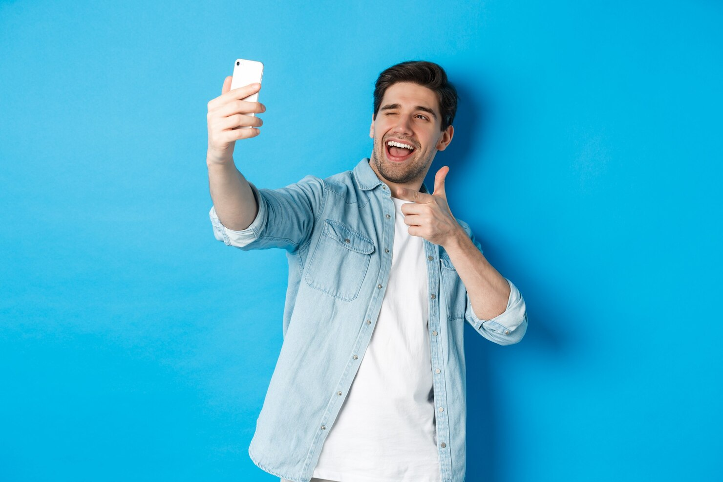 A handsome guy taking selfie on smartphone.
