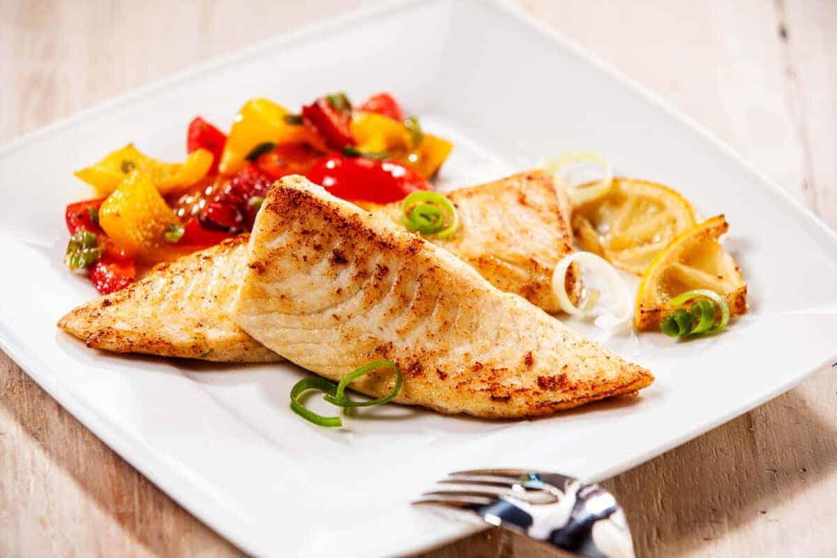 File de tilapia afumat într-un bol cu ​​ardei roșu și galben
