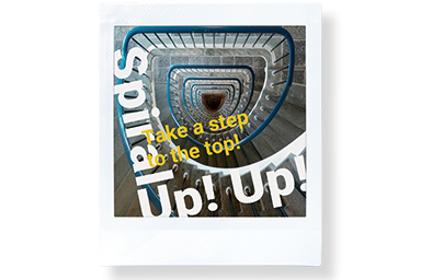 [photo] Top view of a long spiral staircase with the words "Spiral Up" and "Take a step to the top"