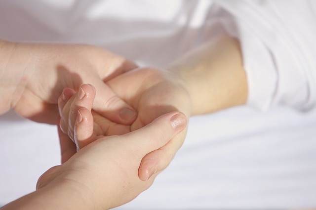 An Occupational Therapist works on a patient's hands.