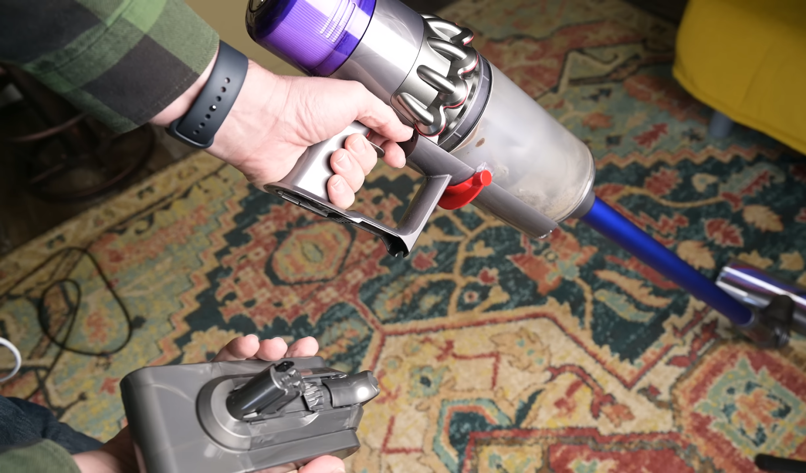 Person detaching the battery from the Dyson V11 cordless vacuum