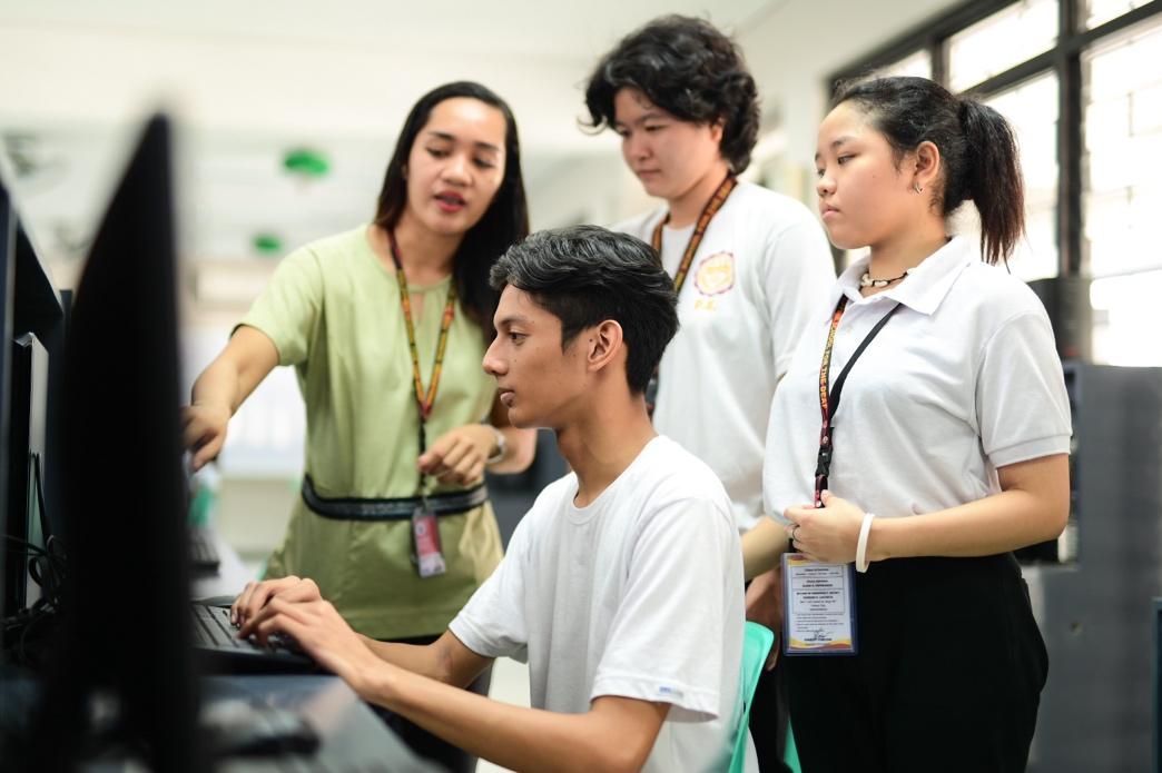 A group of people looking at a computer

Description automatically generated