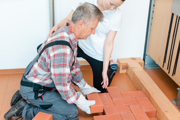 A worker in occupational therapy carefully relearning the art of laying bricks. The occupational therapist provides guidance and support during the retraining process, highlighting the importance of skill development and adap