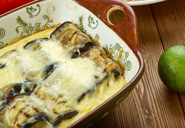 Eggplant lasagna in a ceramic dish placed on a wooden table