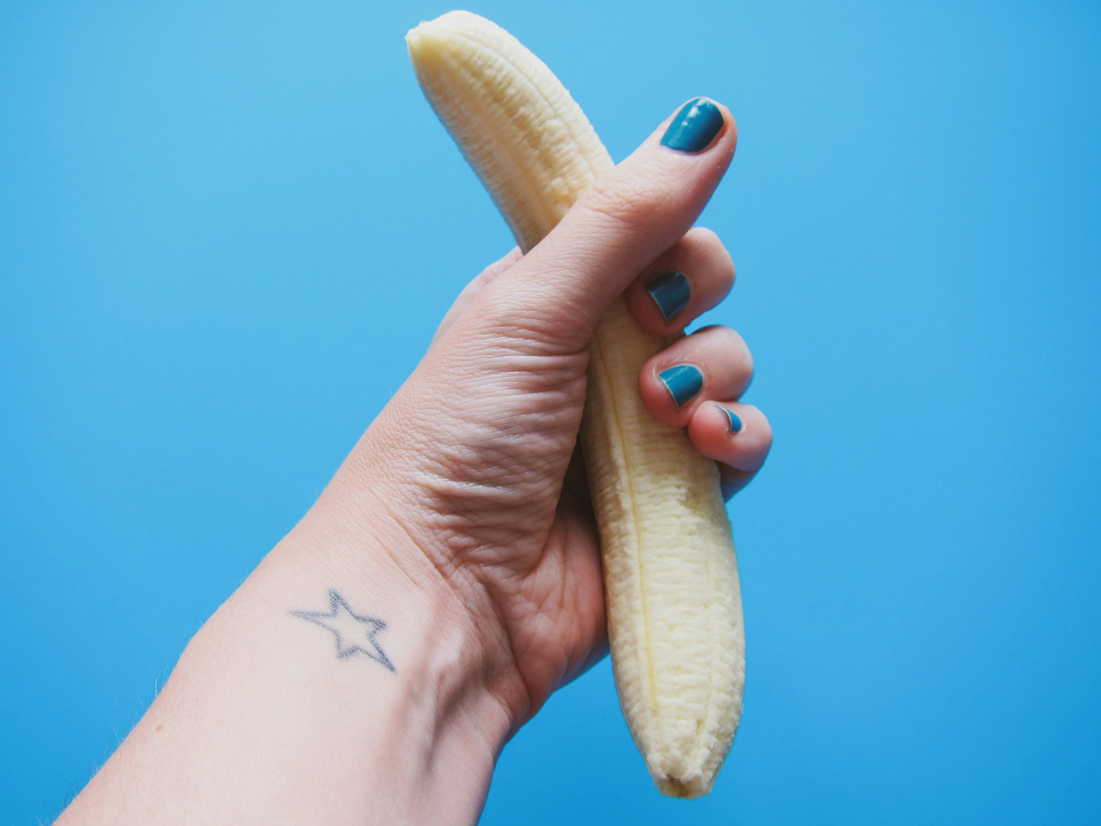 A banana representing a penis being gently squeezed, solving premature ejaculation - https://unsplash.com/photos/person-holding-peeled-banana-fruit-WlB1xhXAYOc