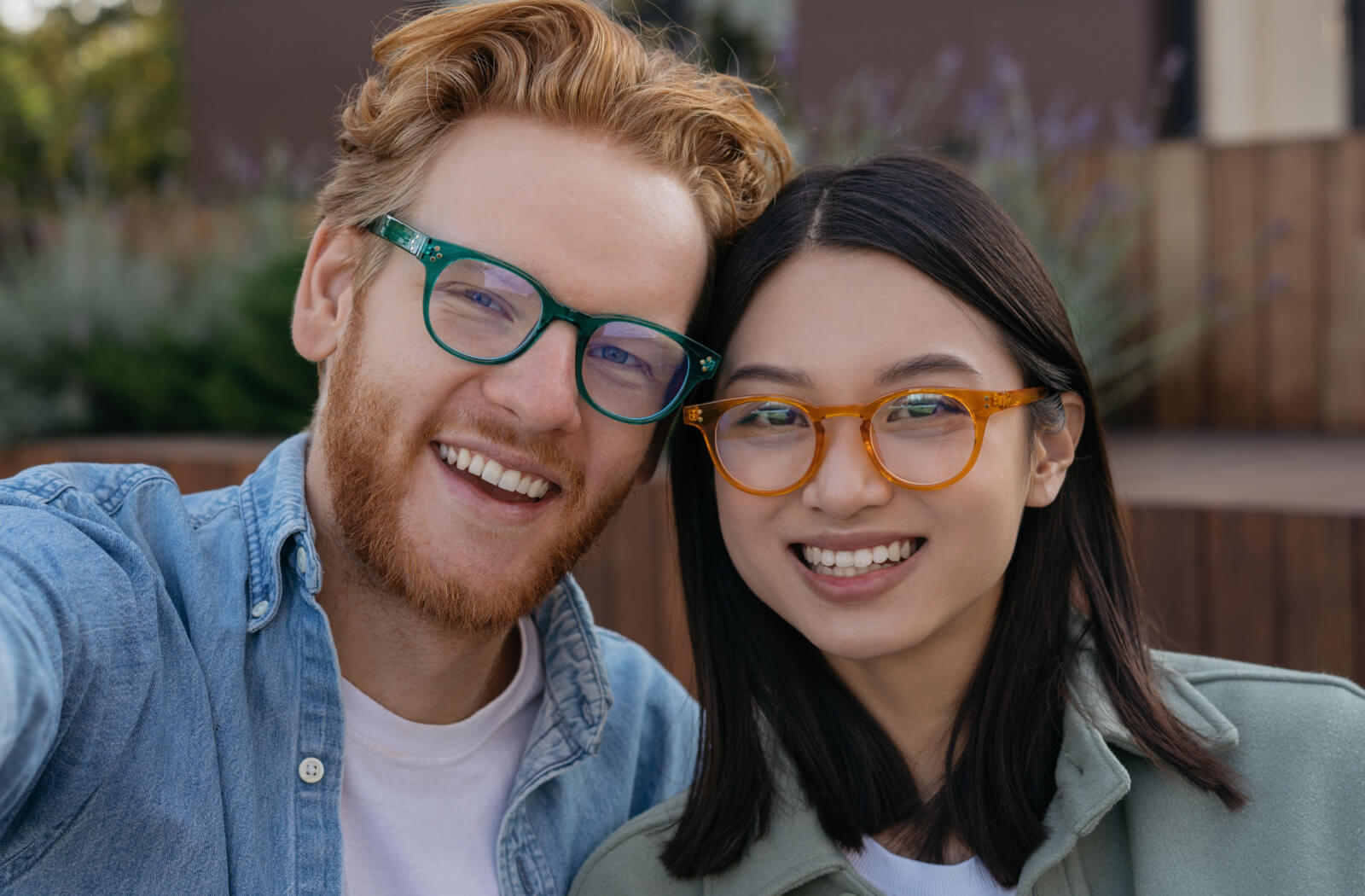 A close-up of a young couple both wearing a pair of stylish glasses.