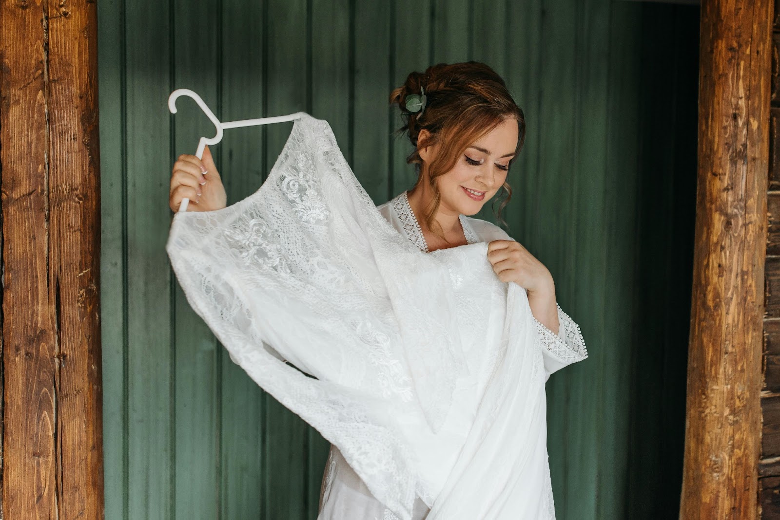 A bride holding her wedding dress glowing in anticipation for the big day!