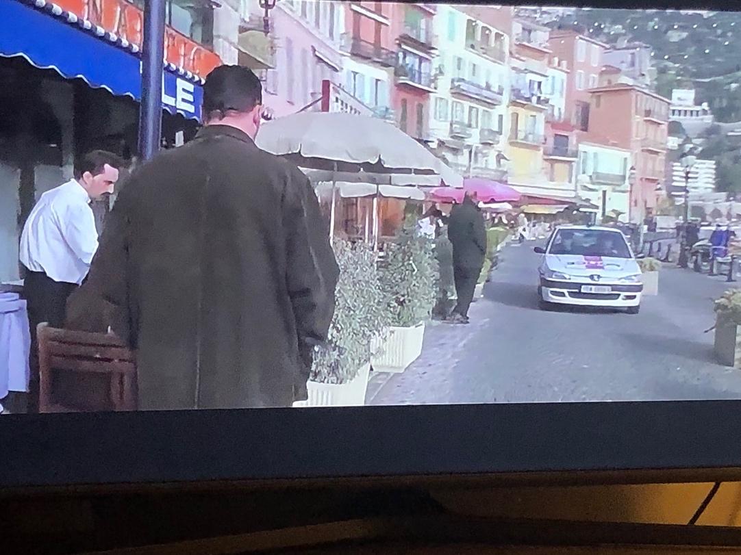 A television screen showing a person walking down a street

Description automatically generated